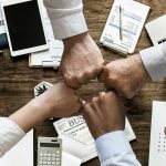 čtyři lidé natahují pěsti